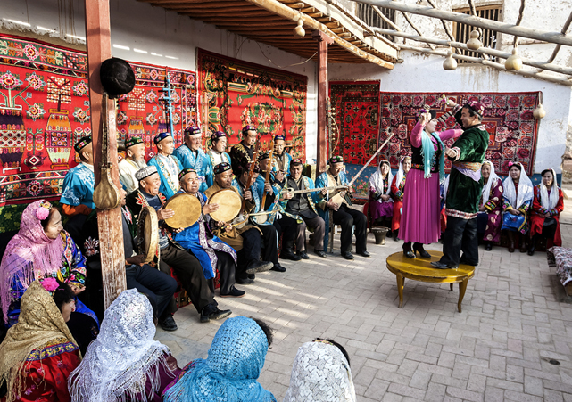 哈密市民间艺人在院落中跳起哈密木卡姆桌子舞